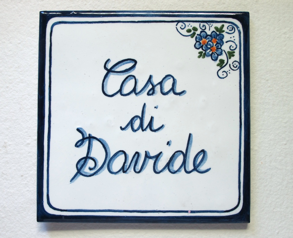 Produzione targhe, numeri civici e insegne fatte a mano. Targa, insegna in ceramica dipinta a mano quadrato e rettangolare.
Disegno personalizzato su misura a Bologna.